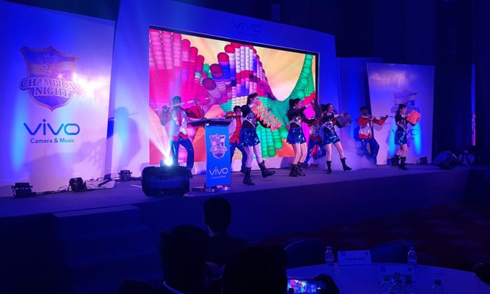 Same dance troupe performing on the Vivo Champions Night stage under purple/blue lighting.