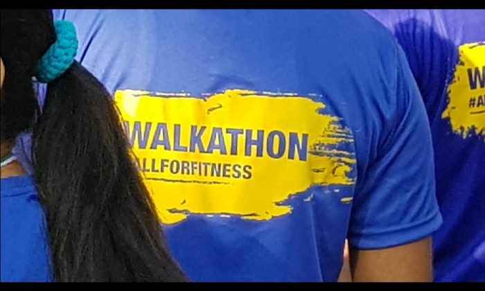 Close-up of a participant's blue t-shirt printed "WALKATHON #ALLFORFITNESS".