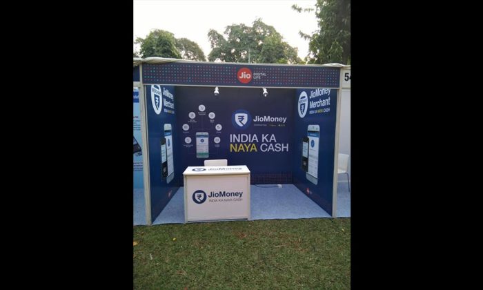 Empty outdoor exhibition booth branded "JioMoney - India Ka Naya Cash" with promotional signage and a reception counter.