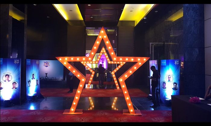 Illuminated orange star-shaped photo-op archway in a hotel lobby, Vivo Champions Night banners visible on either side.