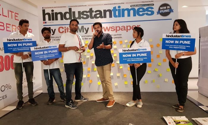 People posing with "Hindustan Times Now in Pune" placards in front of a step-and-repeat backdrop reading "My City My Newspaper".